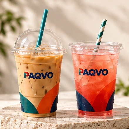 Clear cold cups with iced coffee and a red iced drink with paper straws